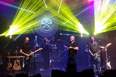 Pink Floyd tribute band on stage with lights and singing