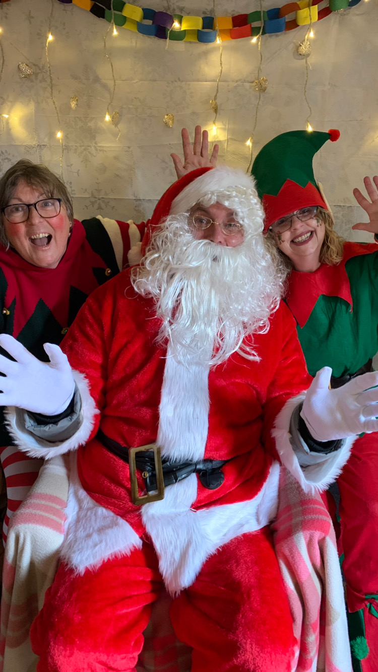 Father Christmas laughing with 2 elves